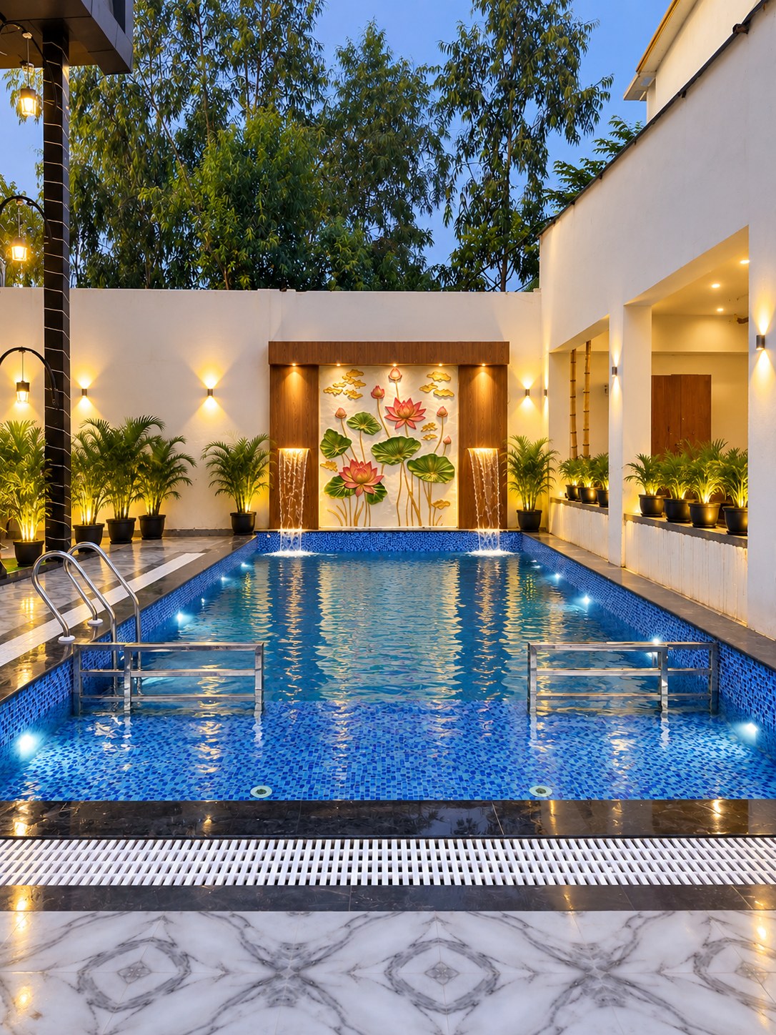 Swimming pool at dusk with a lotus-motif water feature at Manoram Resorts