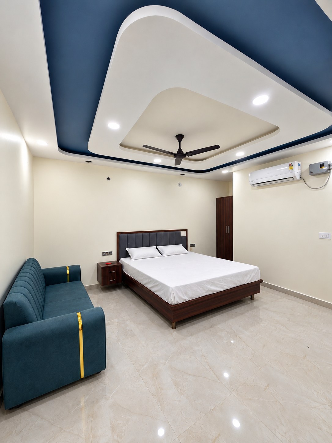 Premium guest room with sofa seating and designer false ceiling